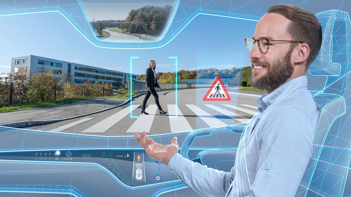 Mann sitzt in einem virtuellen Auto und erkennt einen Fußgänger auf einem Zebrastreifen