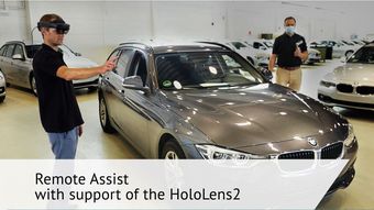  Two engineers stand in front of a car with a HoloLens 2