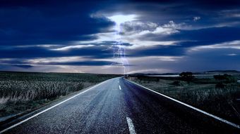 Aufnahme einer Straße mit einem Gewitter am Horizont