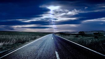 Aufnahme einer Straße mit einem Gewitter am Horizont